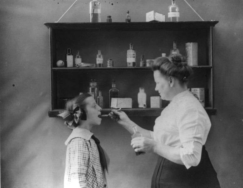 vintage photo of mother giving medicine to child